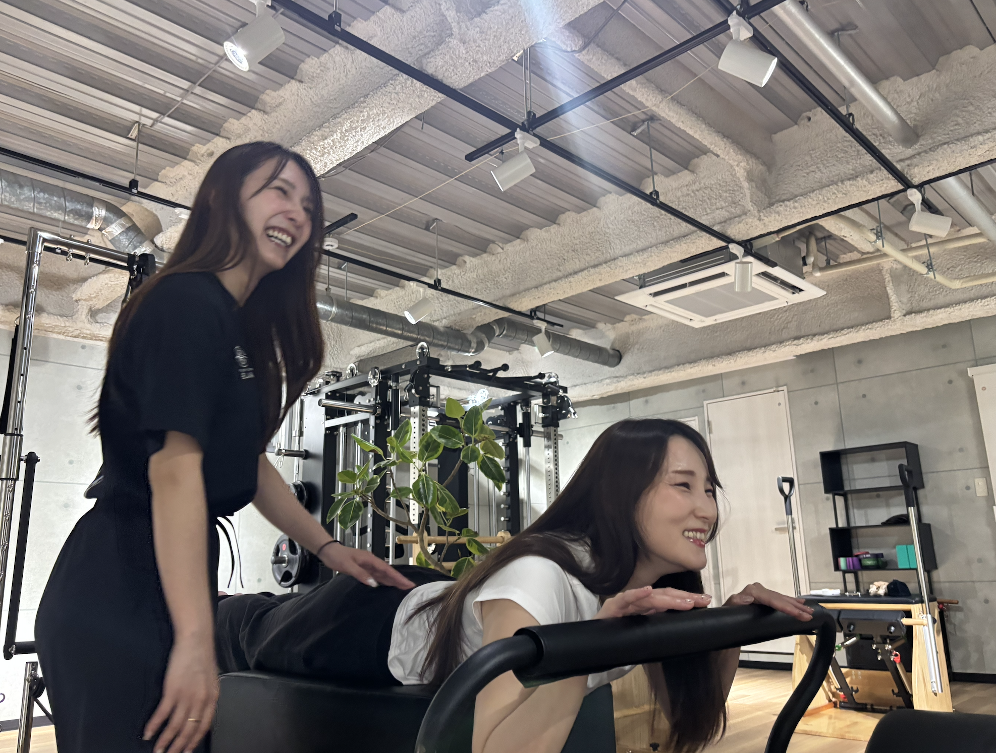 ÉLANのプライベートスタジオでインストラクターがマンツーマンでリフォーマーピラティスを指導する様子